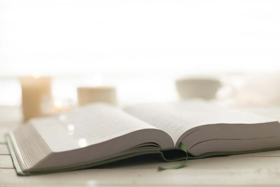 Biblia abierta junto a una vela encendida