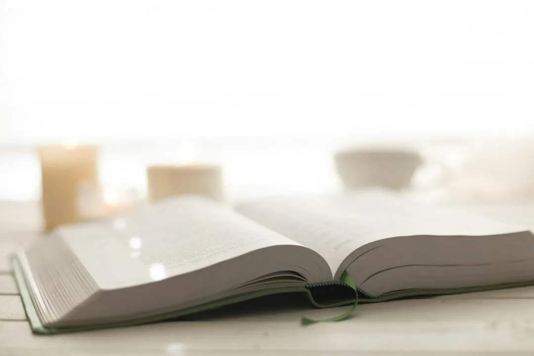 Biblia abierta junto a una vela encendida
