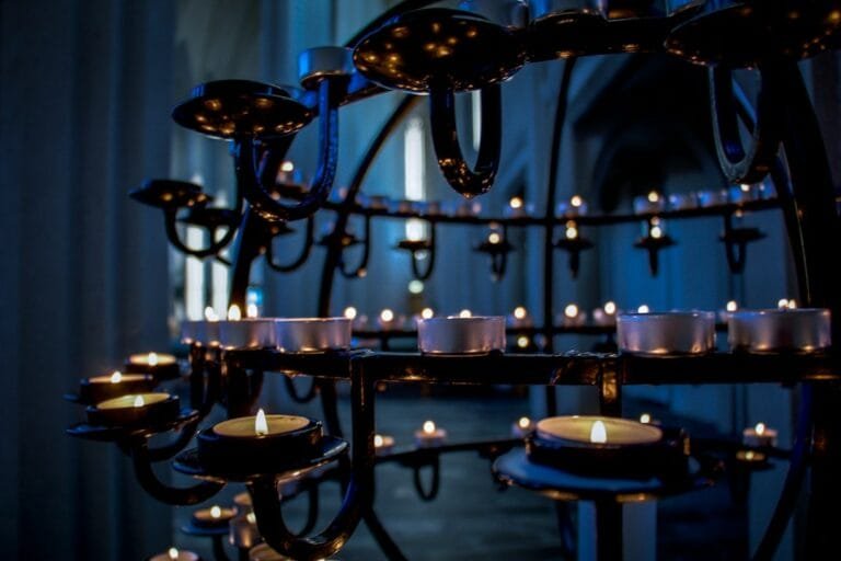 Velas encendidas en una iglesia, símbolo del Día de Todos los Santos